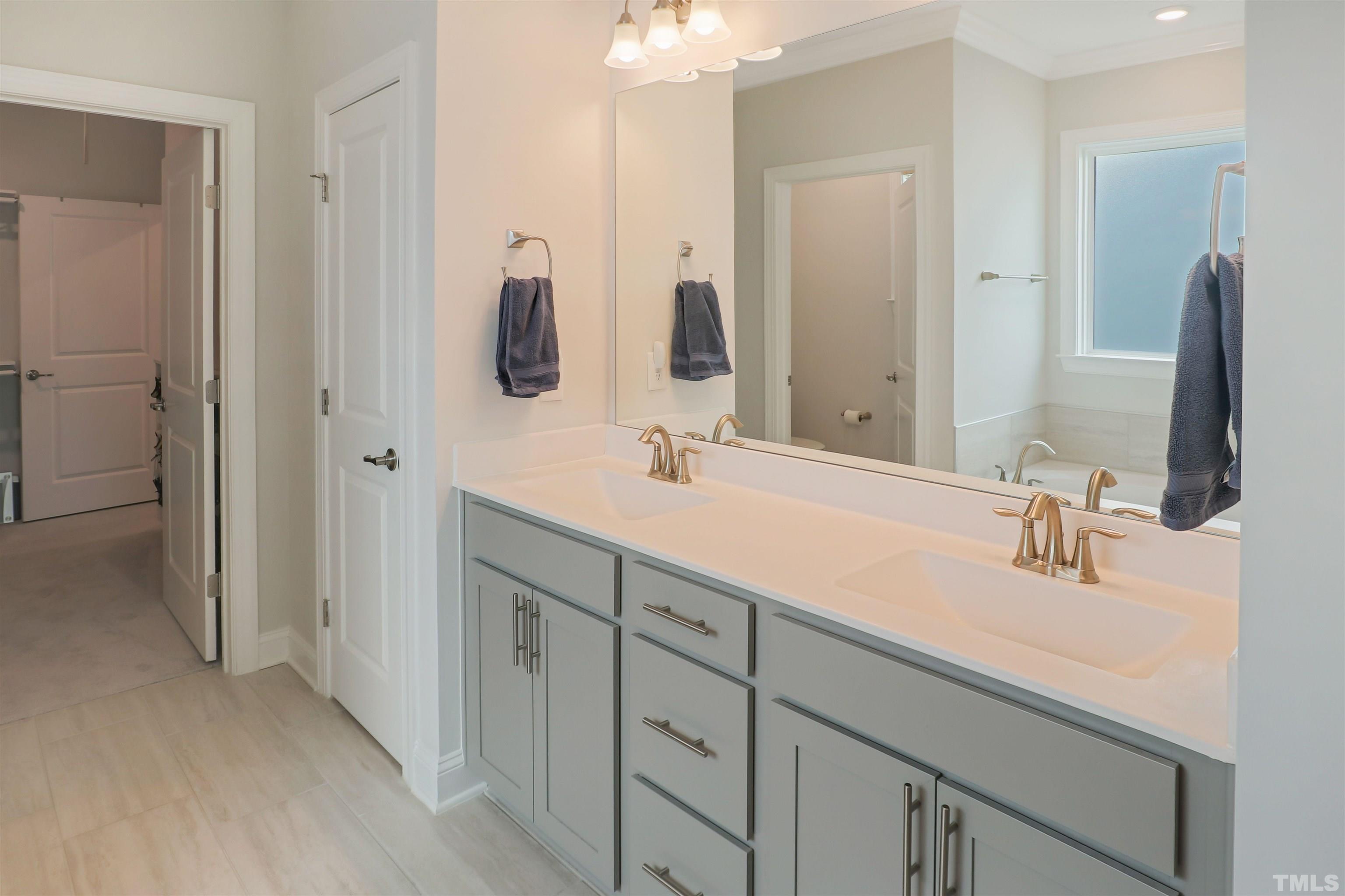 107 Ivory Lane Raleigh, NC 27610 - Photo 14 of 25 a bathroom with double vanity sink a vanity and mirrors