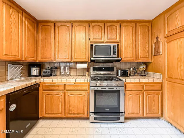a kitchen with stainless steel appliances granite countertop a stove top oven microwave and cabinets