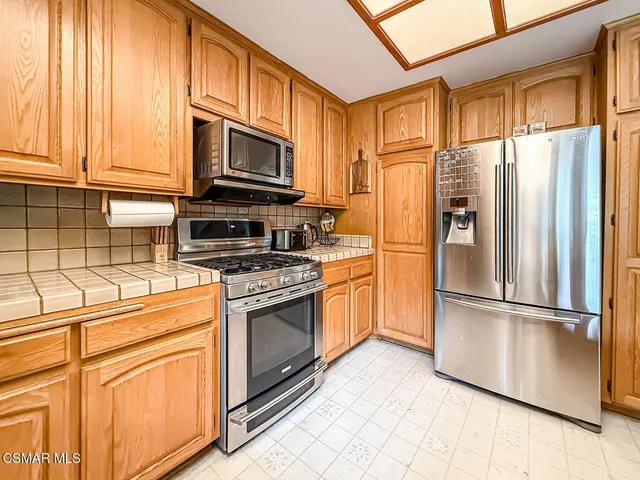 a kitchen with stainless steel appliances granite countertop a refrigerator stove and sink
