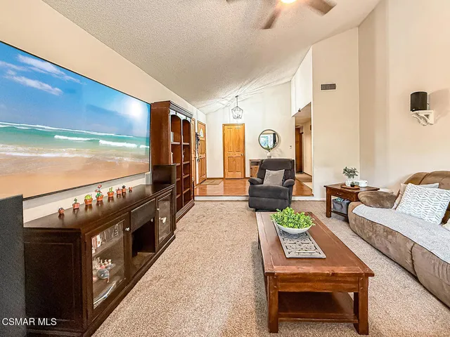 a living room with furniture a flat screen tv and a floor to ceiling window