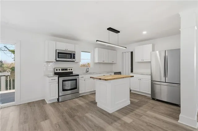 a kitchen with a refrigerator stove and white cabinets
