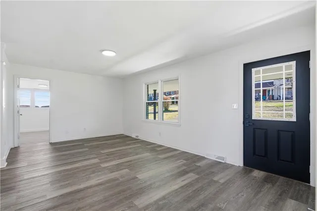 a view of an empty room with closet and a window