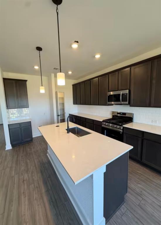 151 Sincere Drive Kyle, TX 78640 - Photo 2 of 15 a room with kitchen island a sink wooden floor and stainless steel appliances