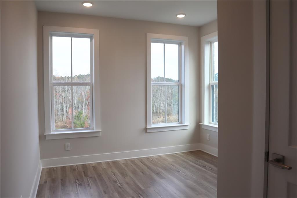 692 Urban Grange Way Suwanee, GA 30024 - Photo 13 of 23 an empty room with wooden floor and windows