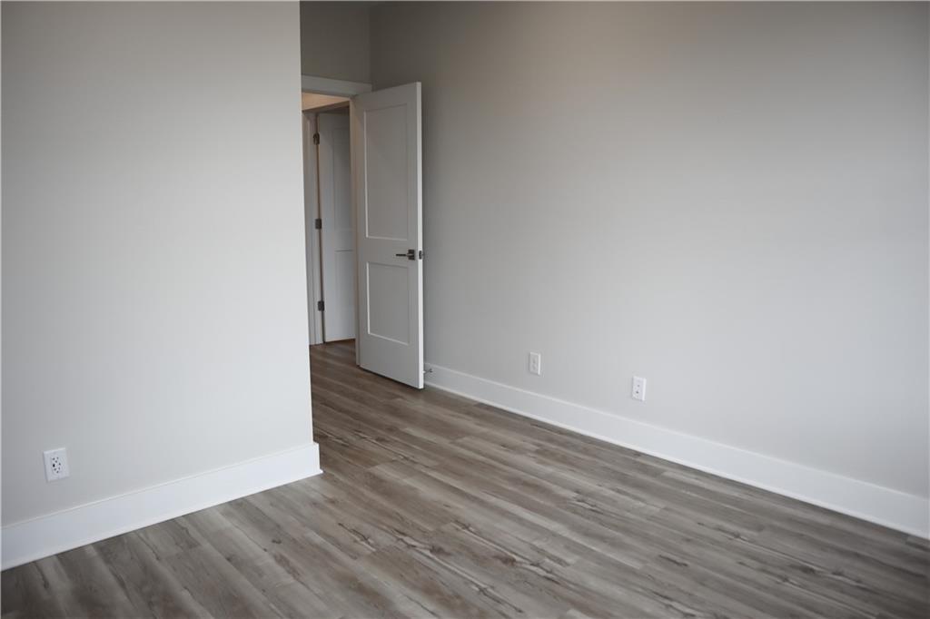 692 Urban Grange Way Suwanee, GA 30024 - Photo 14 of 23 a view of an empty room with wooden floor and a ceiling fan