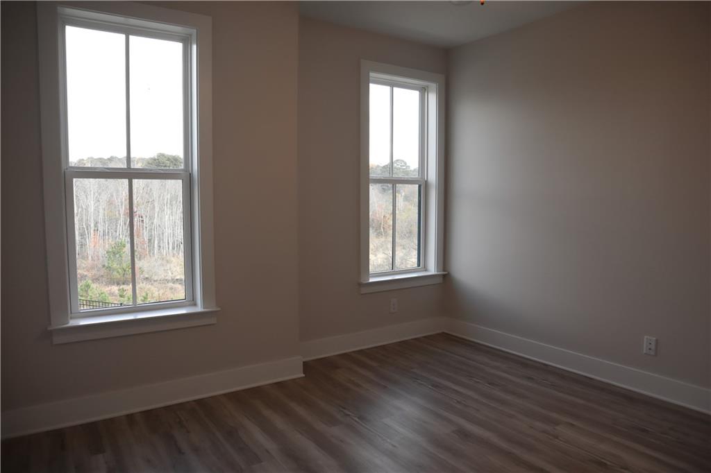 692 Urban Grange Way Suwanee, GA 30024 - Photo 16 of 23 an empty room with wooden floor and windows