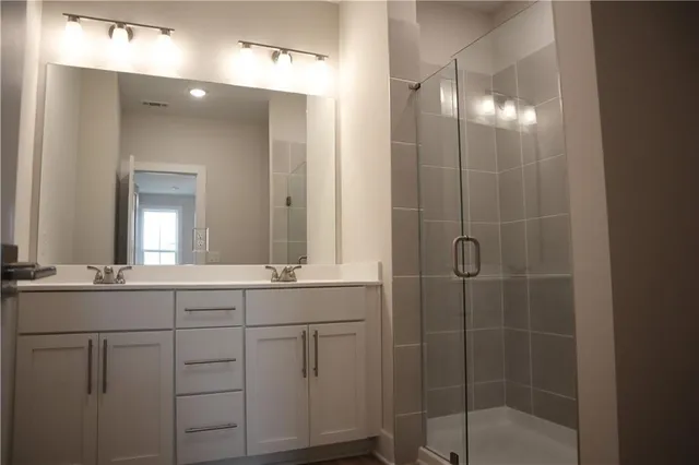 a bathroom with double vanity and a mirror