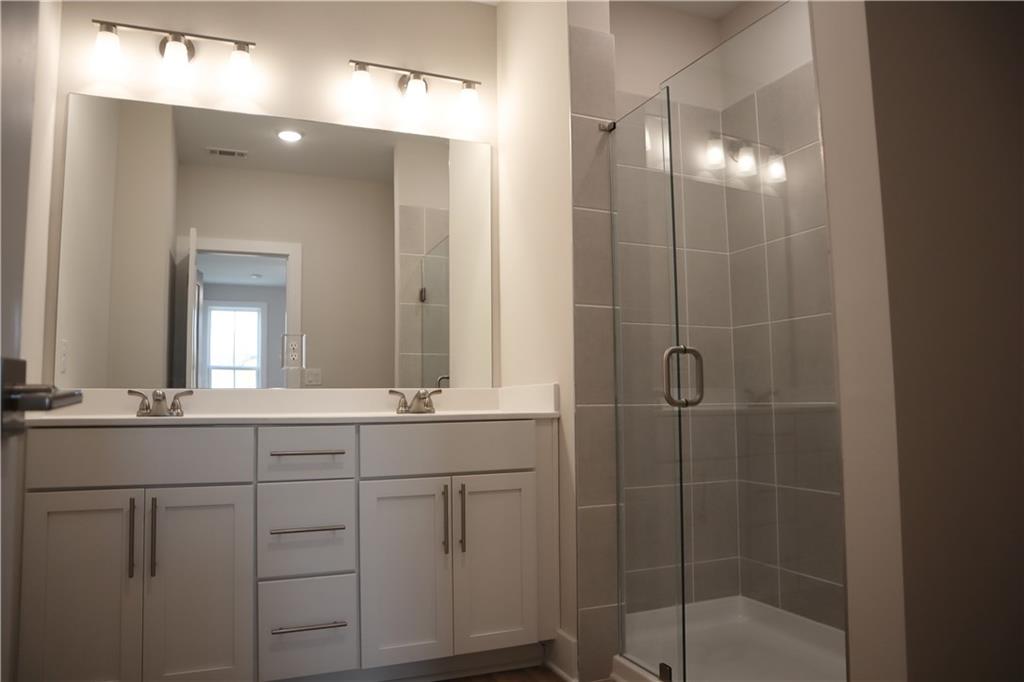 692 Urban Grange Way Suwanee, GA 30024 - Photo 18 of 23 a bathroom with double vanity and a mirror