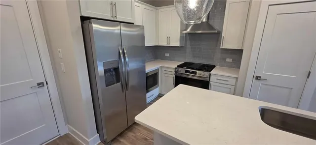 a kitchen with a refrigerator a stove and a sink