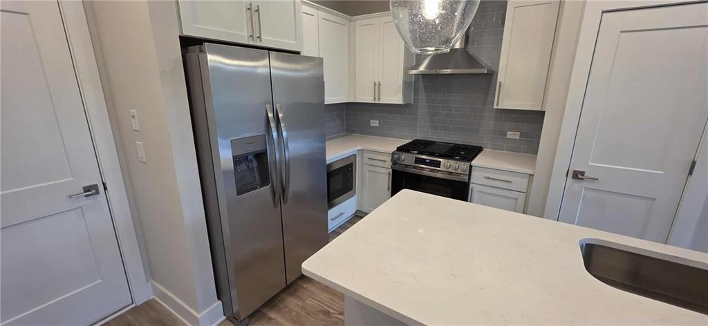 692 Urban Grange Way Suwanee, GA 30024 - Photo 6 of 23 a kitchen with a refrigerator a stove and a sink