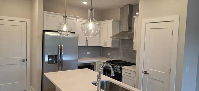 a kitchen with stainless steel appliances a refrigerator and a stove