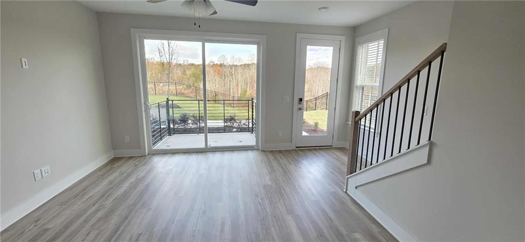 692 Urban Grange Way Suwanee, GA 30024 - Photo 9 of 23 an empty room with wooden floor and windows