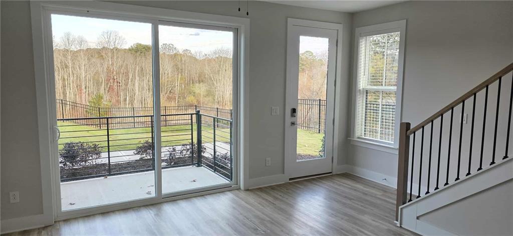 692 Urban Grange Way Suwanee, GA 30024 - Photo 10 of 23 a view of an room with wooden floor and windows