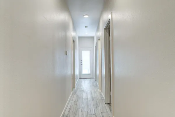 a view of a hallway with wooden floor