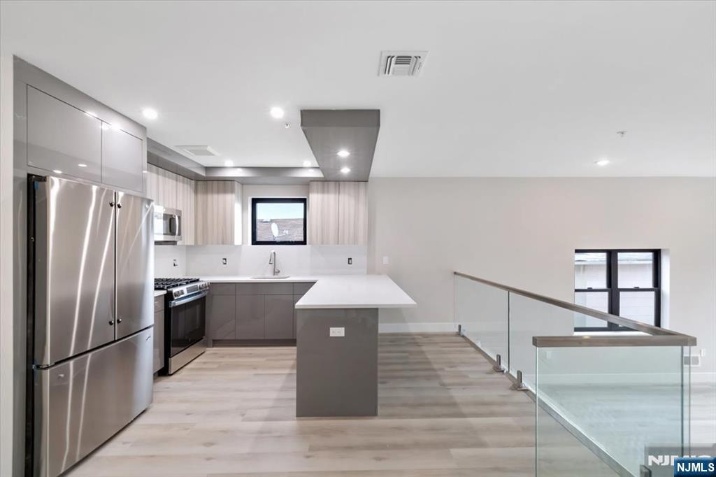 524 64th Street, Unit 2 West New York, NJ 07093 - Photo 1 of 18 a kitchen with kitchen island a counter top space a sink stainless steel appliances and cabinets