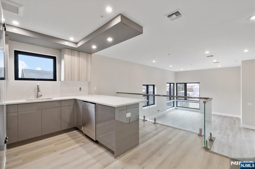 524 64th Street, Unit 2 West New York, NJ 07093 - Photo 2 of 18 a large white kitchen with center island and a sink