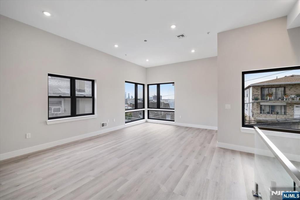 524 64th Street, Unit 2 West New York, NJ 07093 - Photo 3 of 18 a view of an empty room with a window and wooden floor