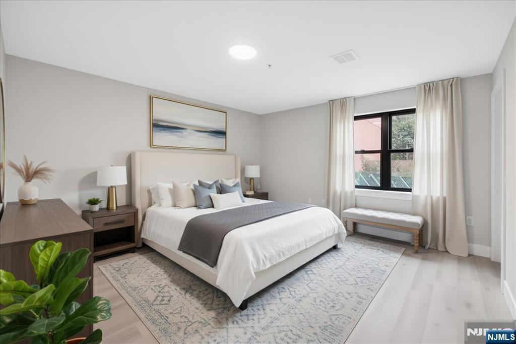 524 64th Street, Unit 2 West New York, NJ 07093 - Photo 9 of 18 a bedroom with a bed a mirror and a window