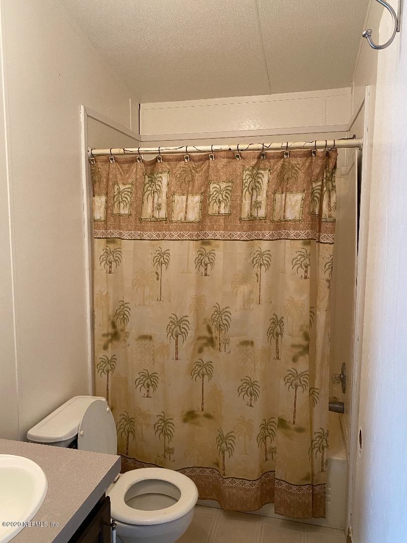 46723 Middle Road Hilliard, FL 32046 - Photo 13 of 14 a bathroom with a granite countertop toilet and a shower