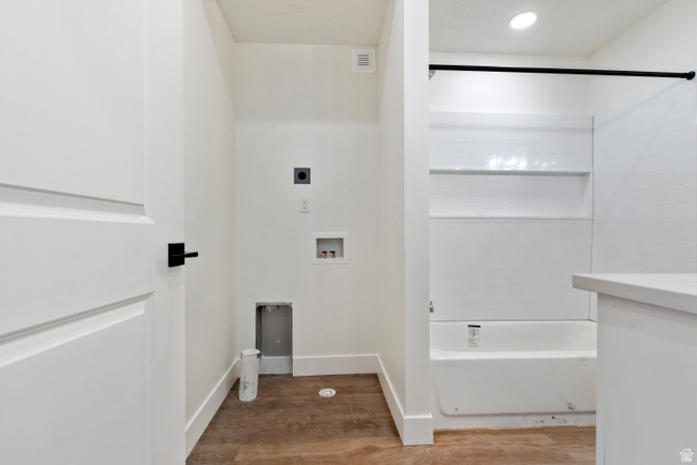 504 North 650 E Street Springville, UT 84663 - Photo 31 of 36 Bathroom featuring a white tub with integrated shelving, matte black shower rod, and wood-finish flooring