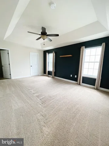 a view of empty room with windows and ceiling fan