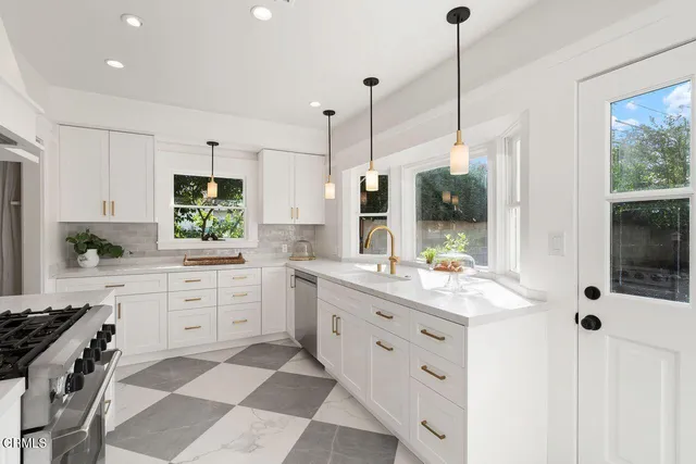 a kitchen with white cabinets and appliances