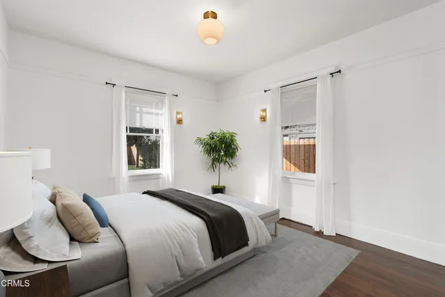 a bedroom with a bed and a potted plant