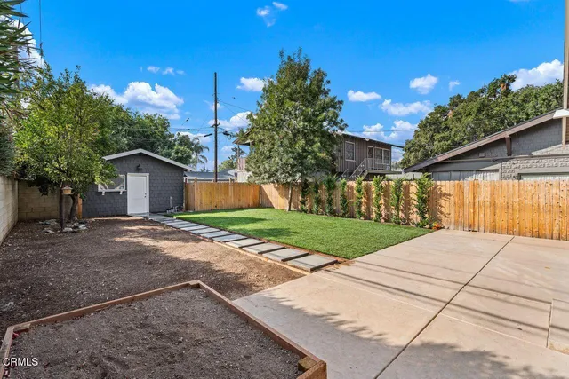 a view of backyard of house and car parked