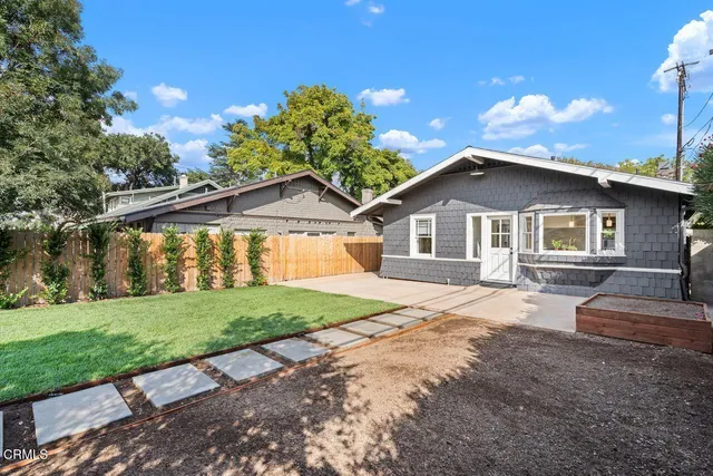 a yellow and red house with a yard