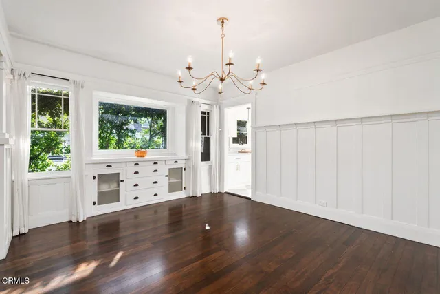 a view of a room with wooden floors and chandelier