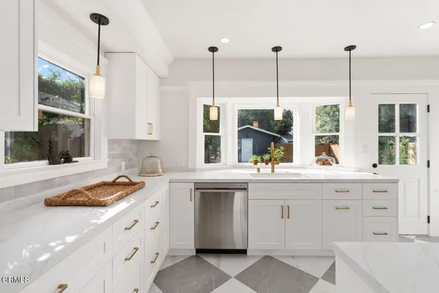 a kitchen with stainless steel appliances granite countertop a stove a sink and a wooden floors
