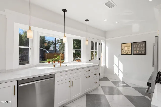 a kitchen with a sink window and cabinets