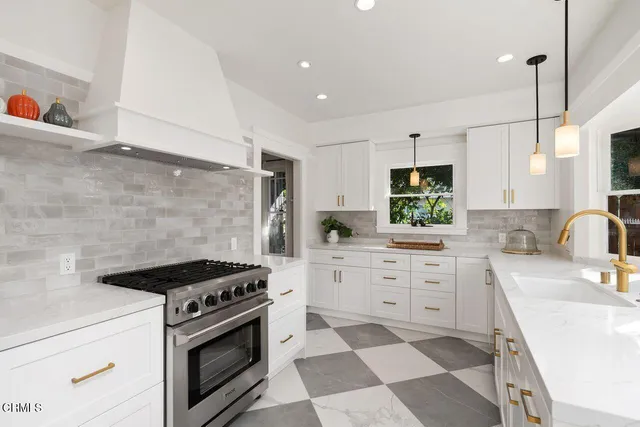 a kitchen with stainless steel appliances a stove a sink and a refrigerator