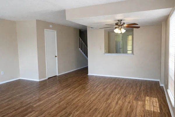 a view of an empty room with wooden floor