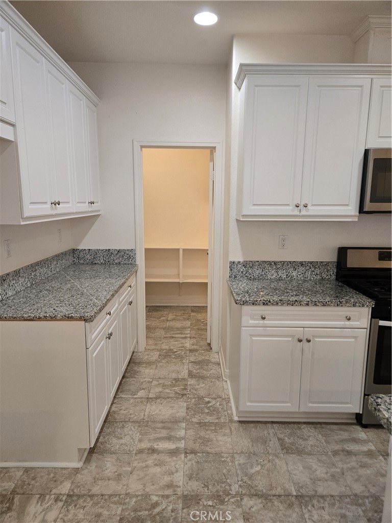 11014 Via Del Corso Riverside, CA 92505 - Photo 8 of 30 a kitchen with granite countertop white cabinets and white appliances