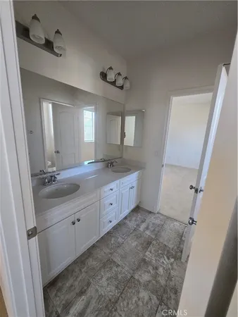 a bathroom with a double vanity sink a mirror and a toilet