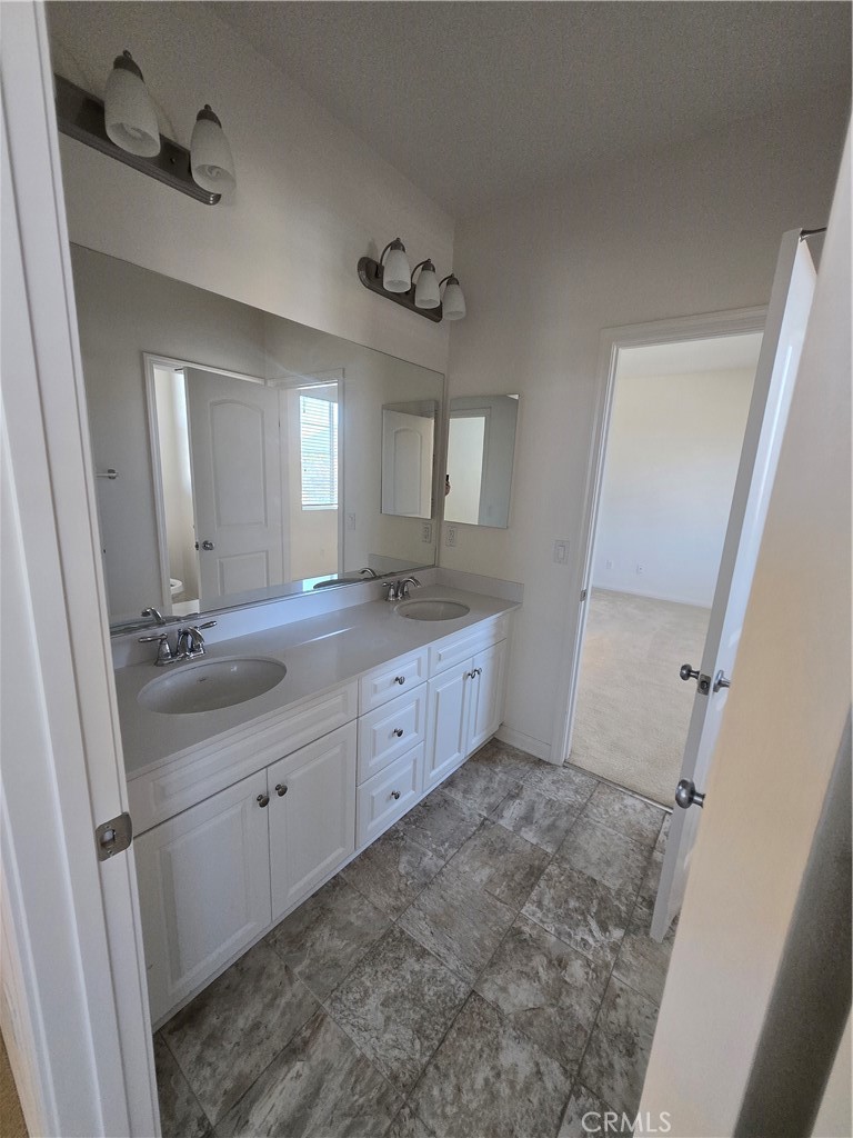 11014 Via Del Corso Riverside, CA 92505 - Photo 10 of 30 a bathroom with a double vanity sink a mirror and a toilet