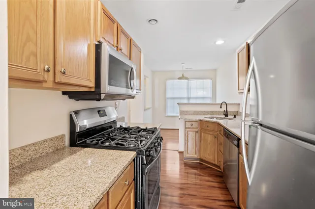 a kitchen with stainless steel appliances granite countertop a stove sink and cabinets