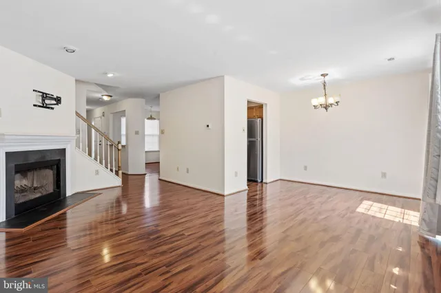 a view of empty room with wooden floor and fireplace
