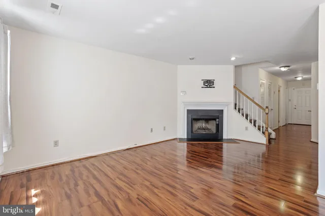 a view of a hallway with wooden floor and a fireplace