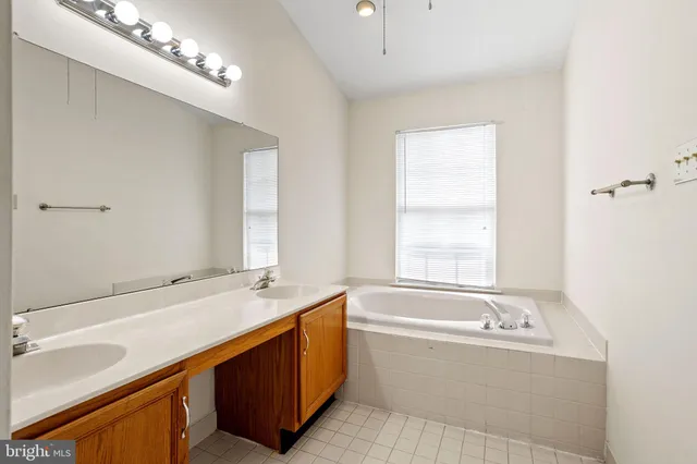 a bathroom with a tub a sink and a window