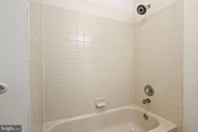 a bathroom with a white bath tub and a shower