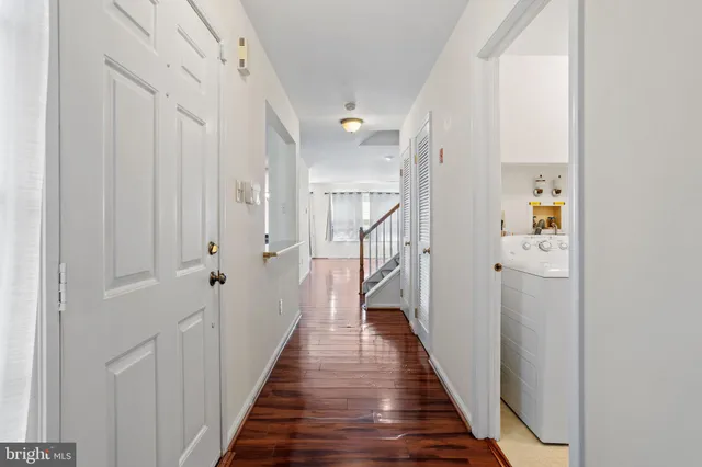 a view of a hallway with wooden floor and staircase