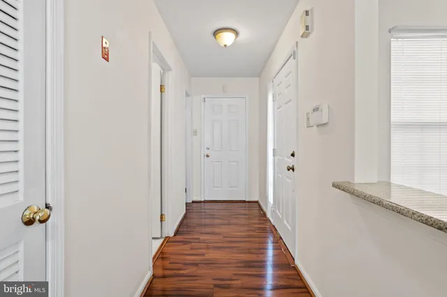 a view of a hallway with wooden floor and staircase