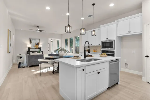 a kitchen with stainless steel appliances granite countertop a sink a stove and a refrigerator