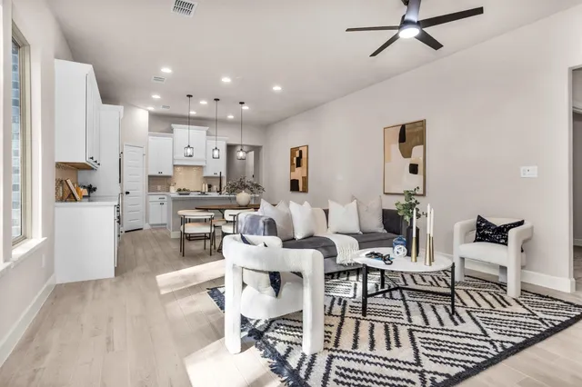 a living room with lots of furniture and kitchen view