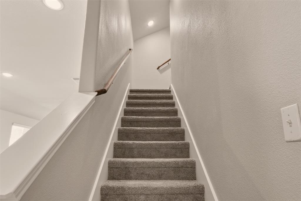 9105 Switchgrass Lane Forney, TX 75126 - Photo 13 of 20 Carpeted staircase with white trim, wood handrail, and recessed lighting