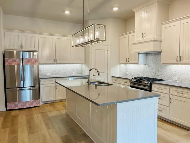 a kitchen with kitchen island a sink stainless steel appliances and cabinets