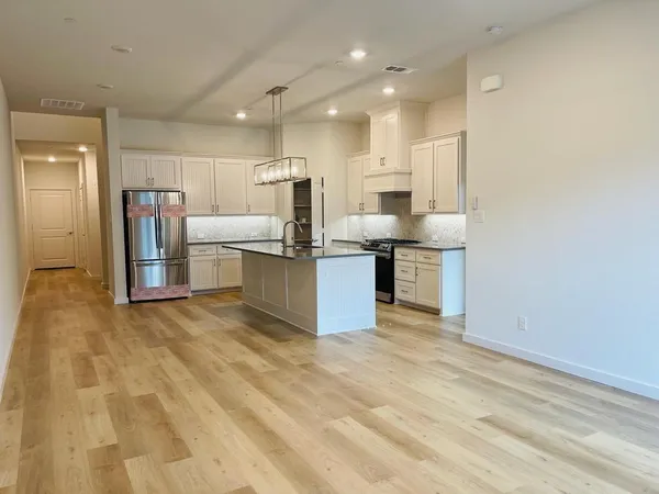 a kitchen with kitchen island a counter top space cabinets and stainless steel appliances