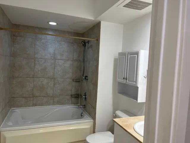 a white bath tub sitting next to a toilet